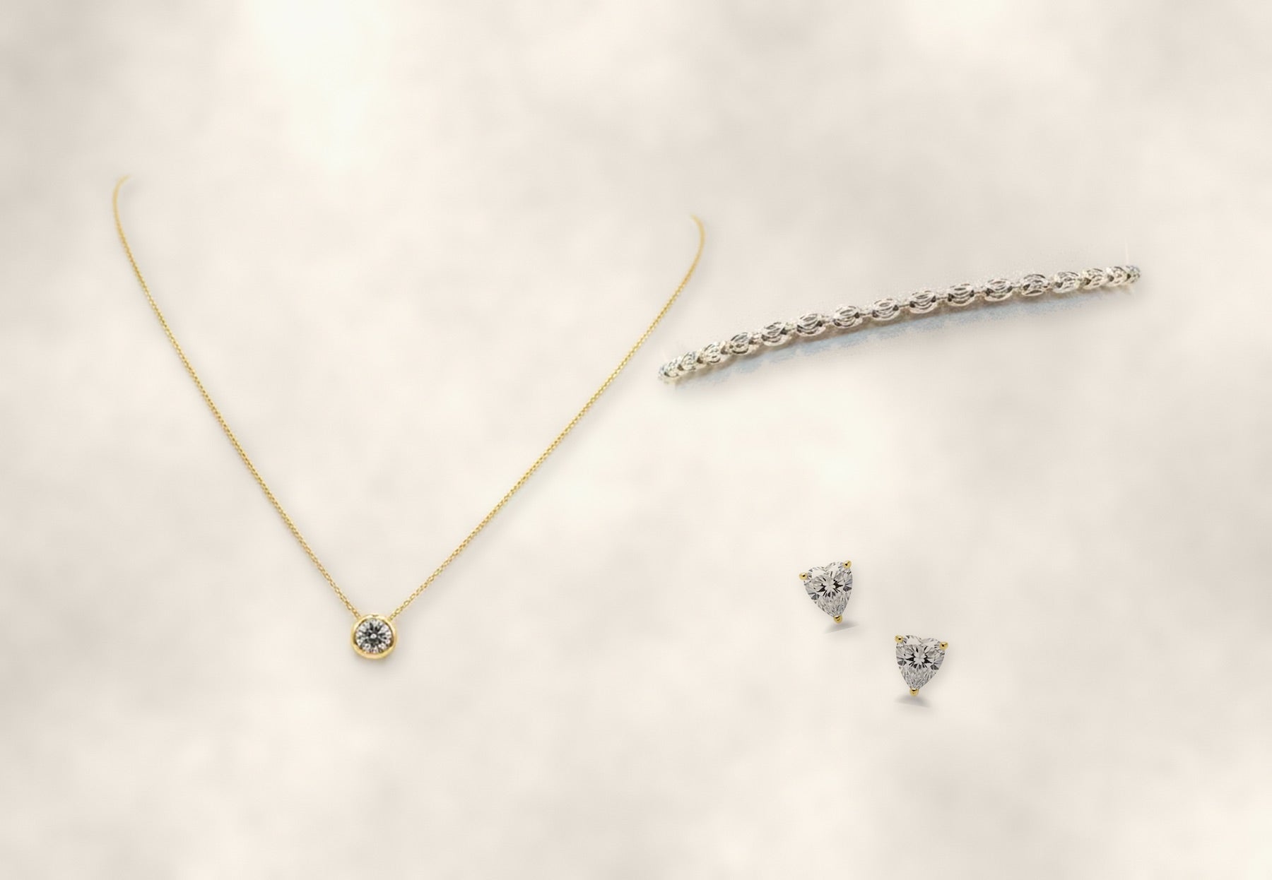 Gold pendant necklace, tennis bracelet, and heart-cut studs